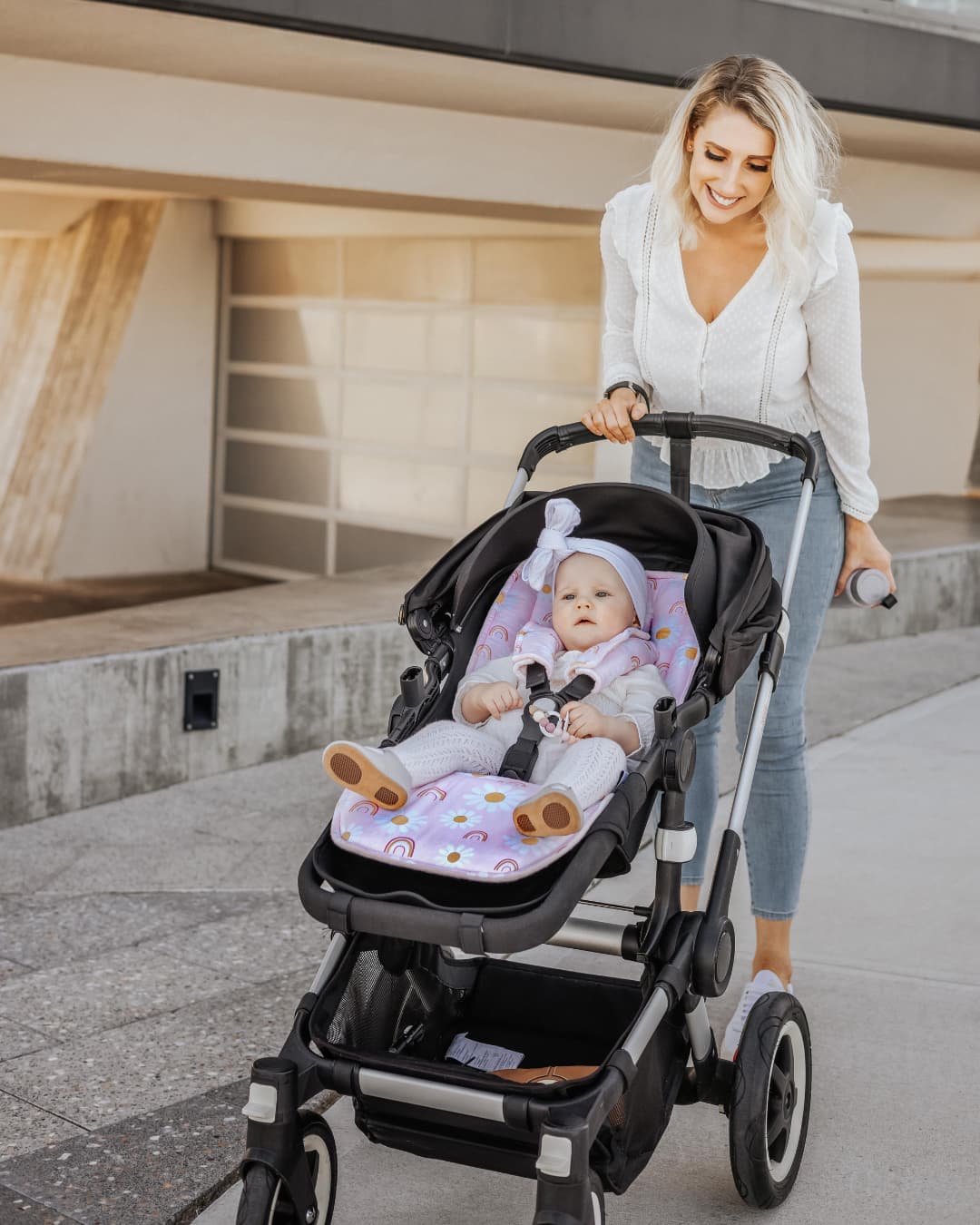 Mother pushing a stroller with baby seated on a padded stroller liner, highlighting comfort, support, and everyday convenience.