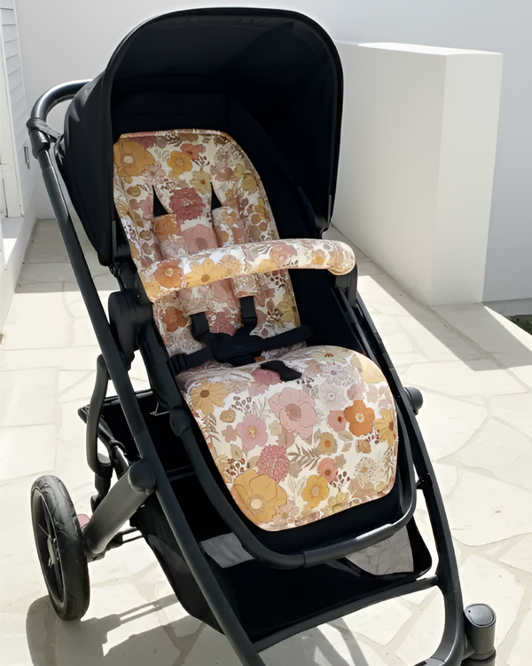 Stroller with floral seat cover on a white background