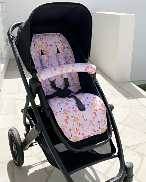 Black stroller with floral-patterned seat covers on a light-colored floor.