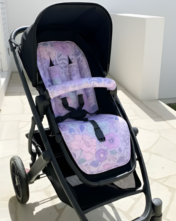 Black stroller with a floral-patterned seat cover on a tiled floor.