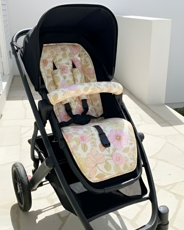 Black stroller with floral cushion on a white floor