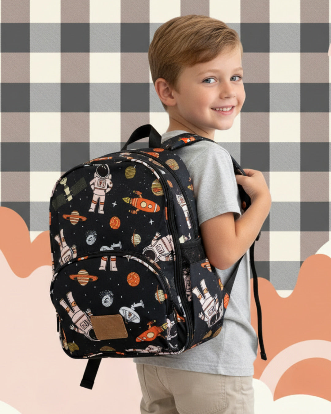Child wearing a space-themed backpack against a checkered wall.
