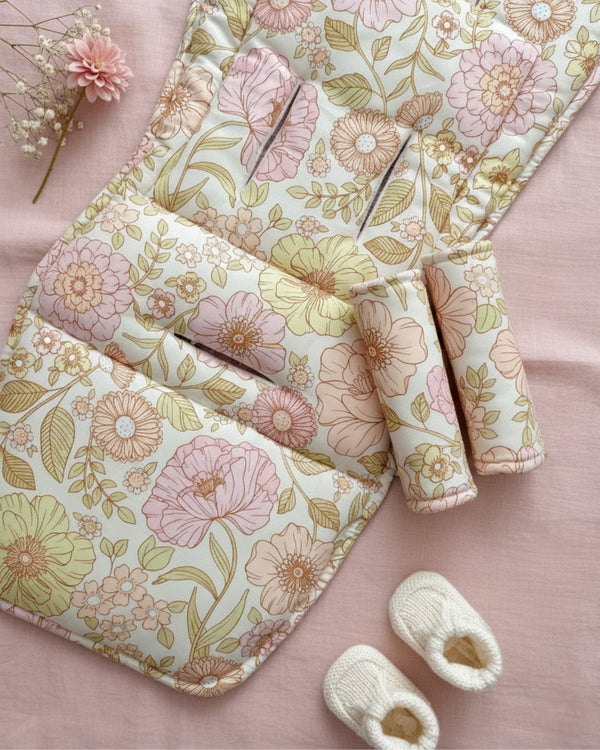 Floral-patterned baby blanket with matching booties on a pink background