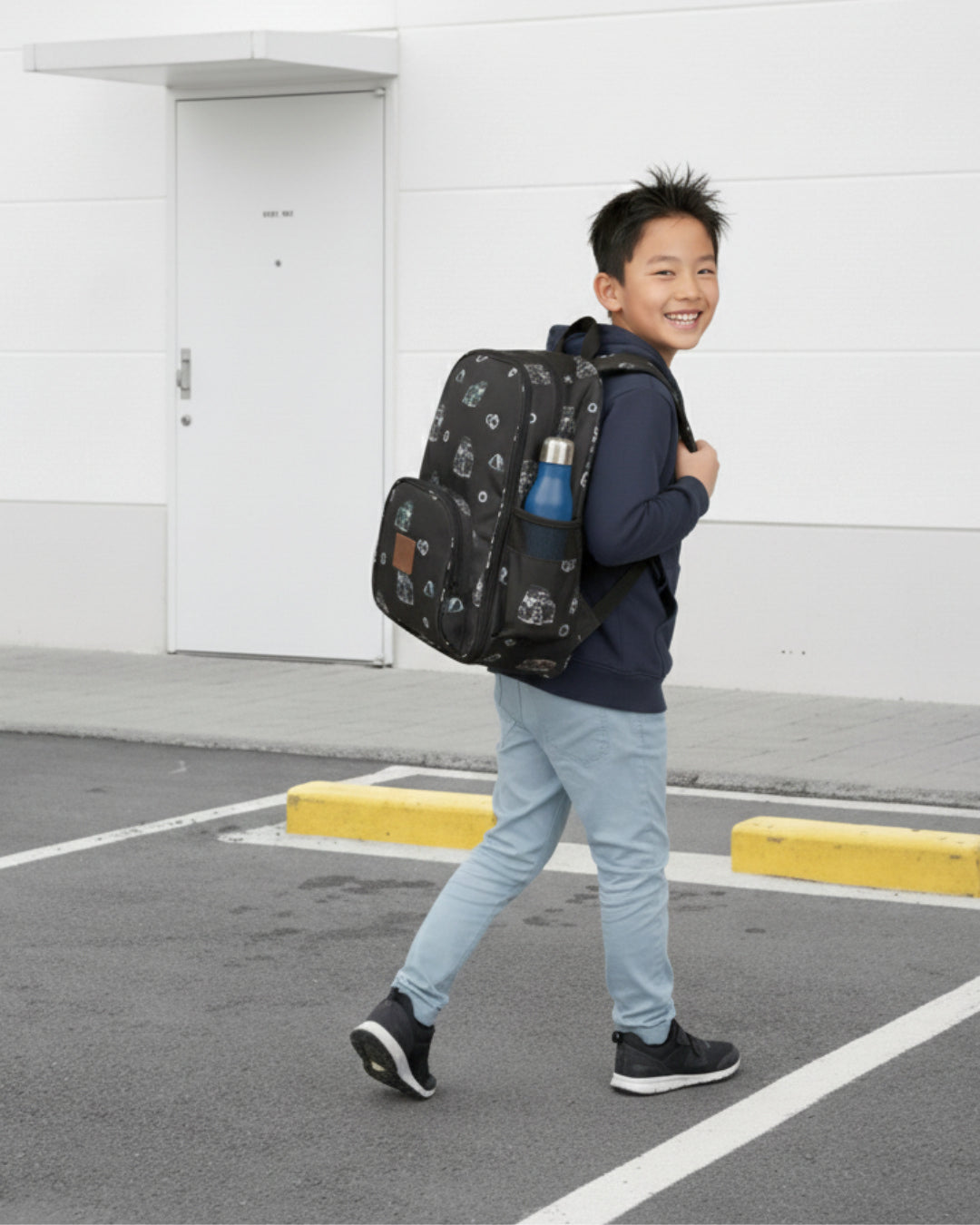 Child walking outdoors with a large backpack on a plain background