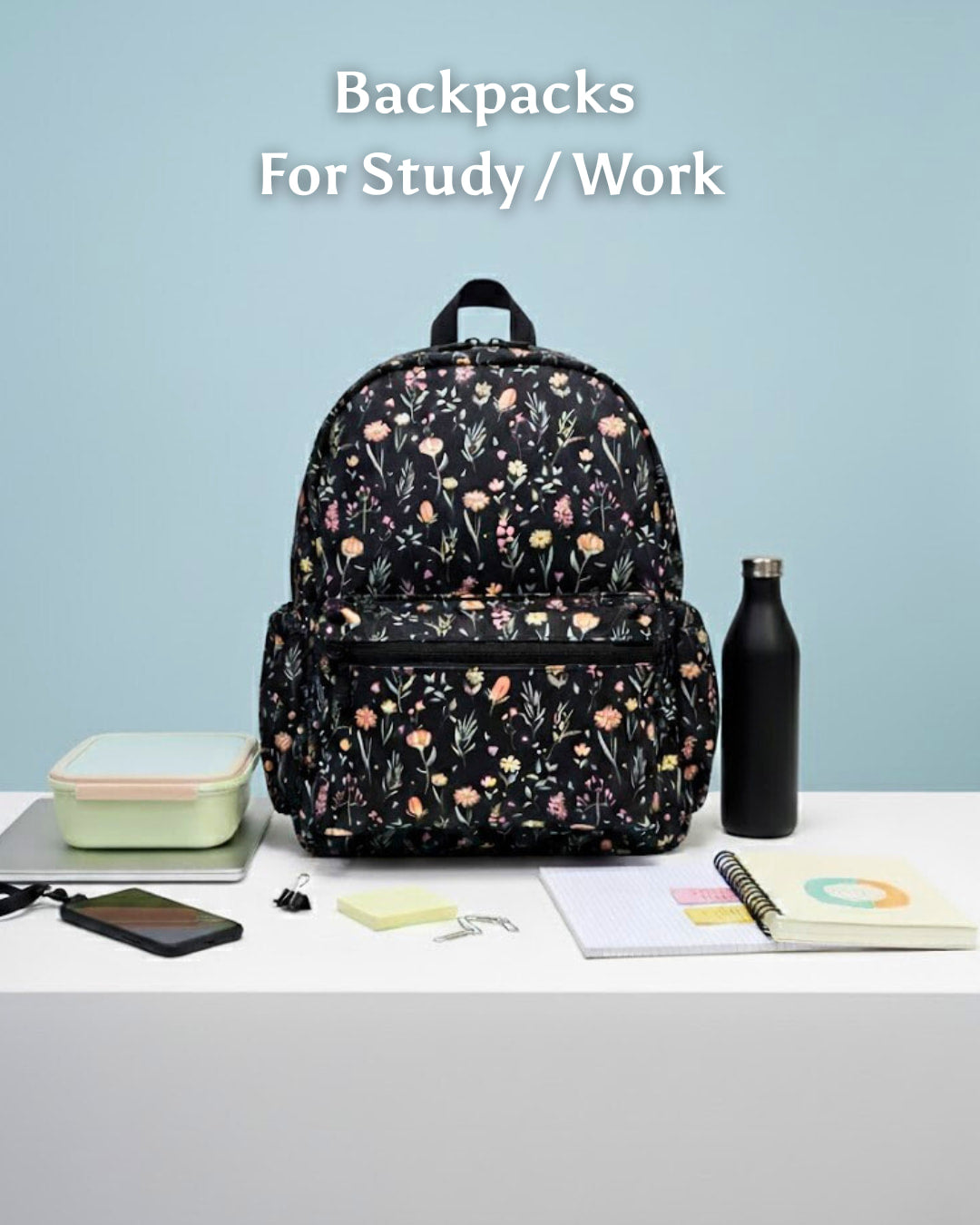 Floral-patterned backpack on a table with stationery items against a light blue background