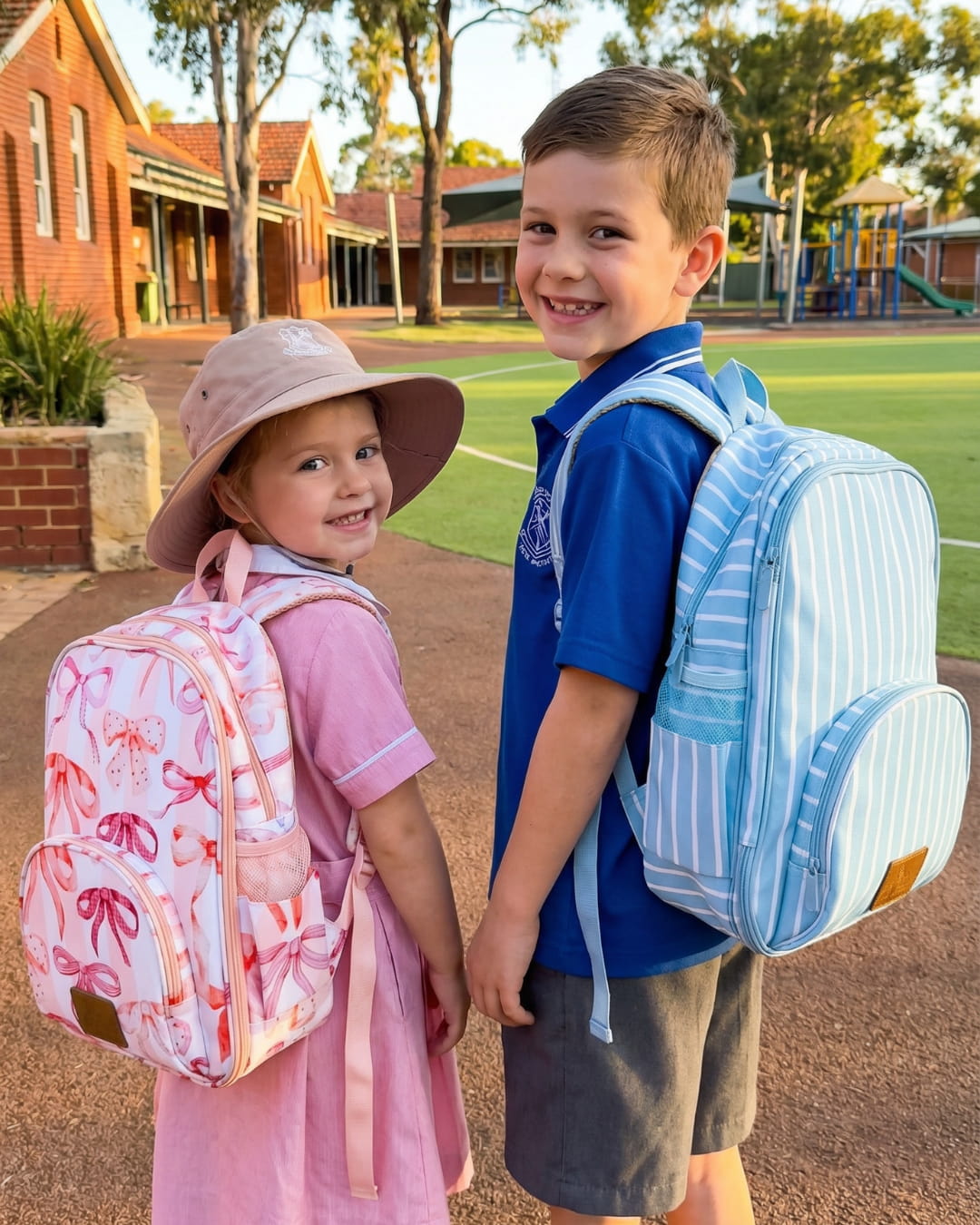 Two children with backpacks standing outdoors near a school building.