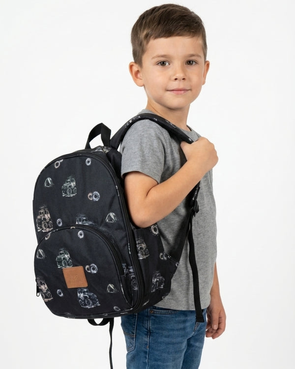 Child wearing a black backpack with car pattern on a white background