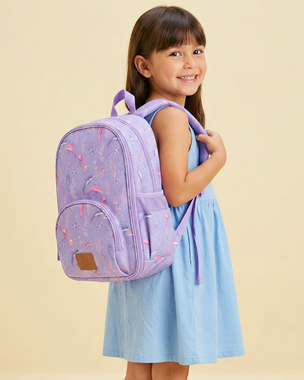 Girl wearing a purple backpack with pink patterns on a beige background