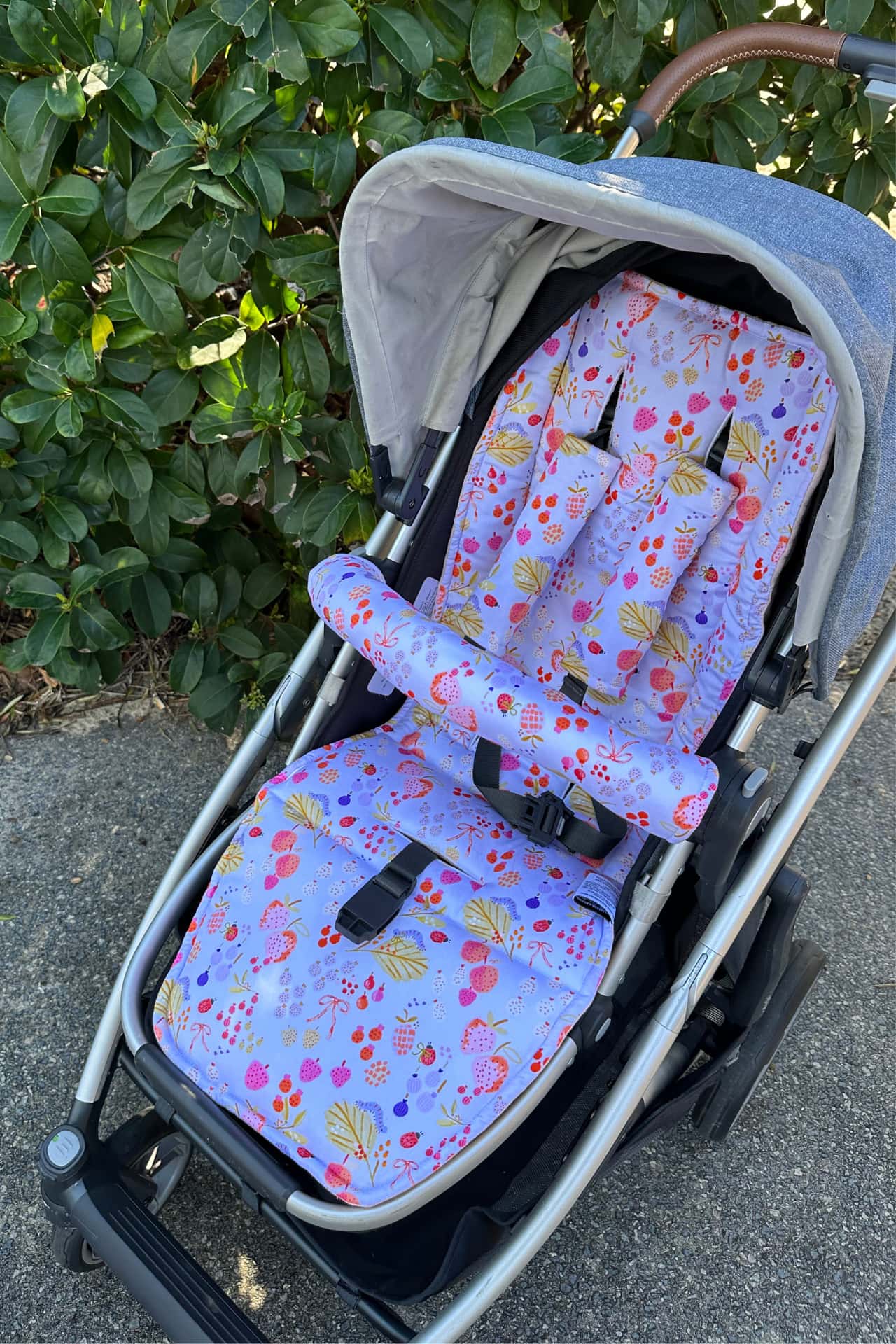 Stroller with floral-patterned seat cover outdoors