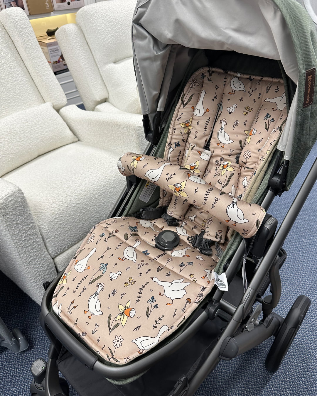 Stroller with patterned seat covers on a blue floor.