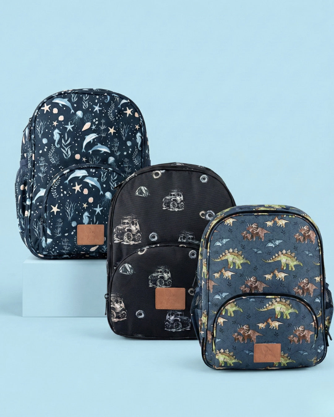 Set of three backpacks with different patterns on a light blue background