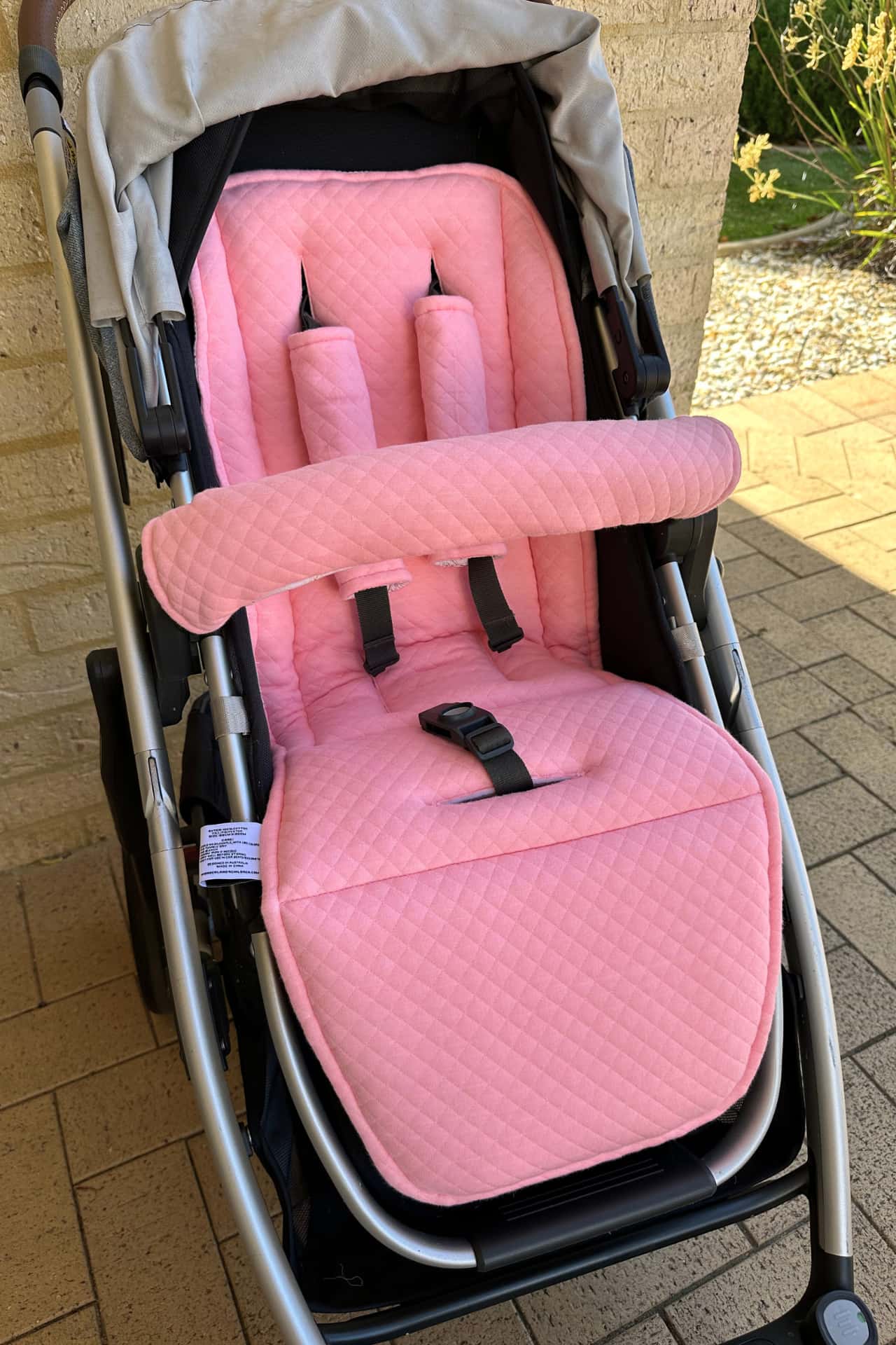 Pink stroller seat cover on a stroller 