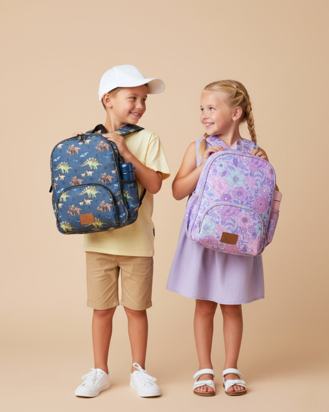 Two children with backpacks on a beige background