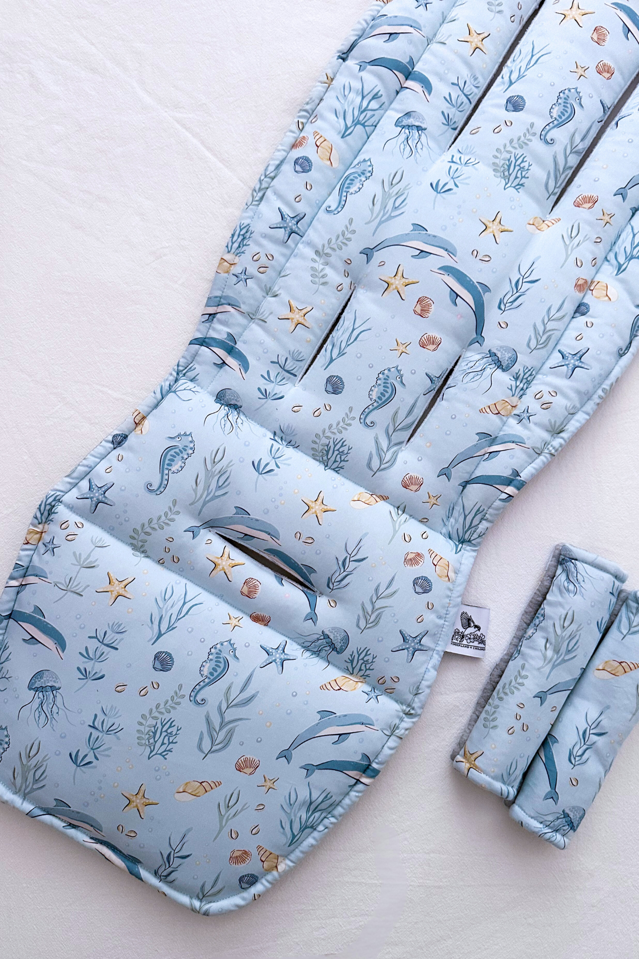 Set of baby stroller cover with ocean-themed pattern on a light background