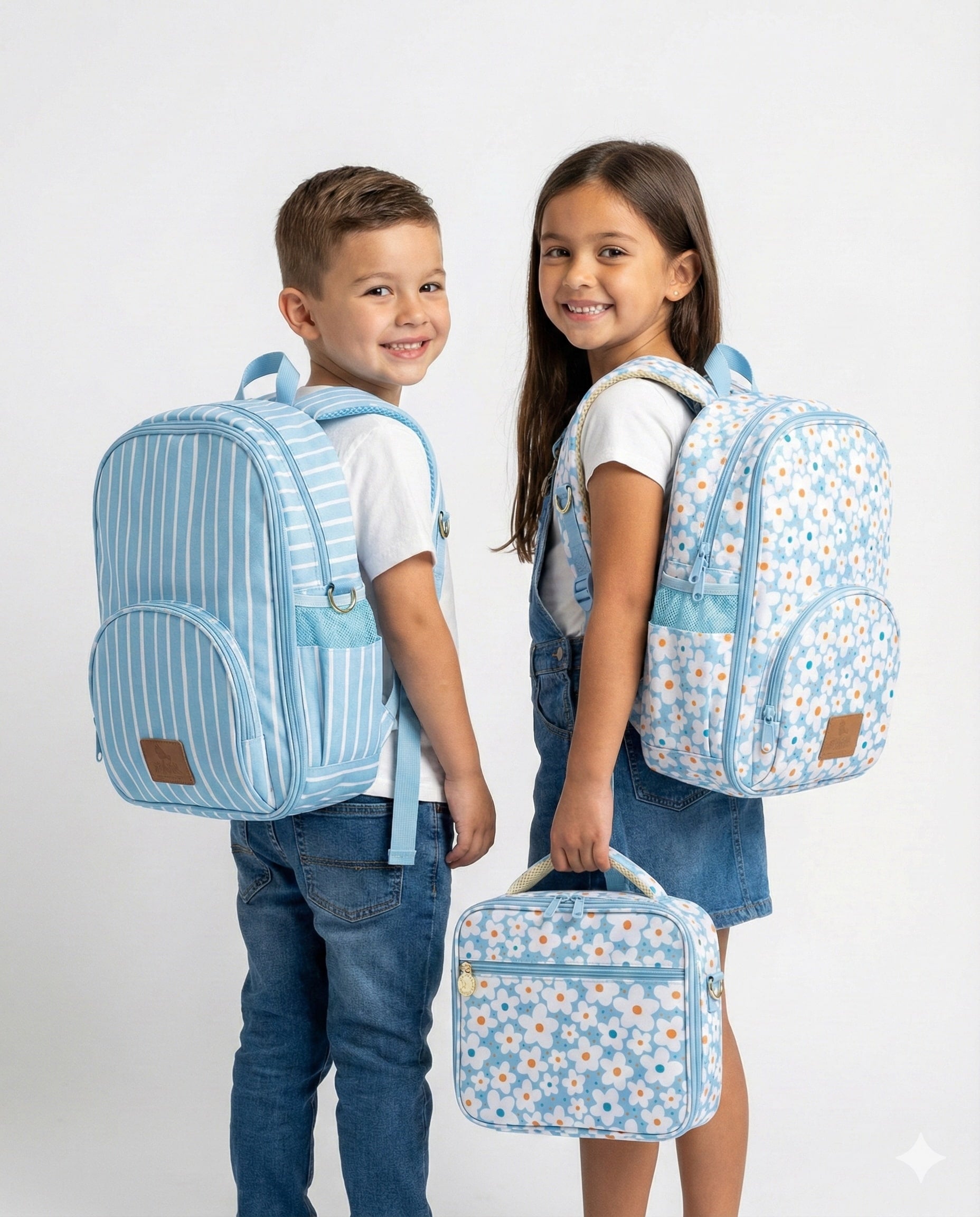 Two children wearing blue backpacks with floral patterns on a white background