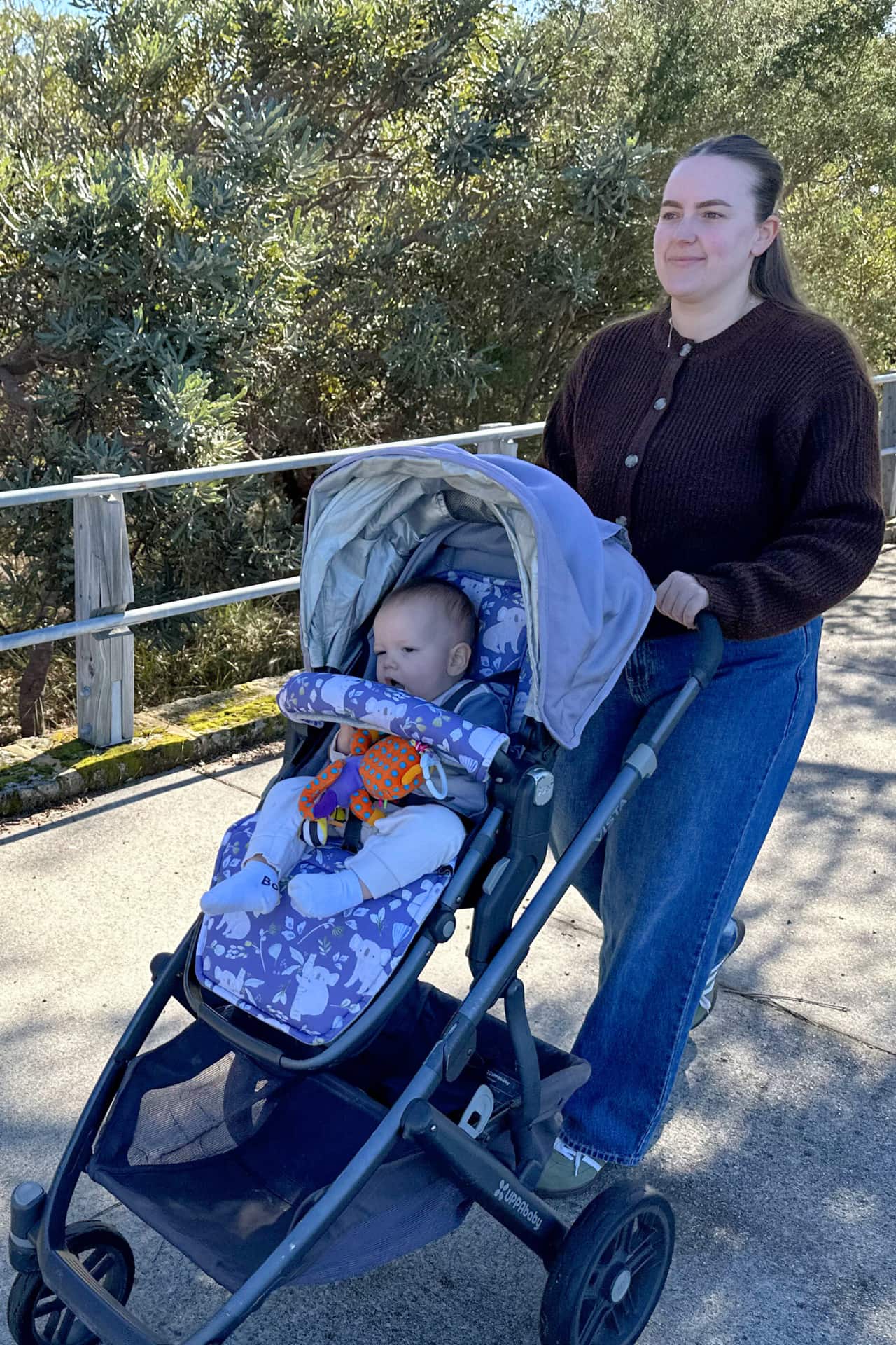 Woman pushing a stroller with a baby outdoors