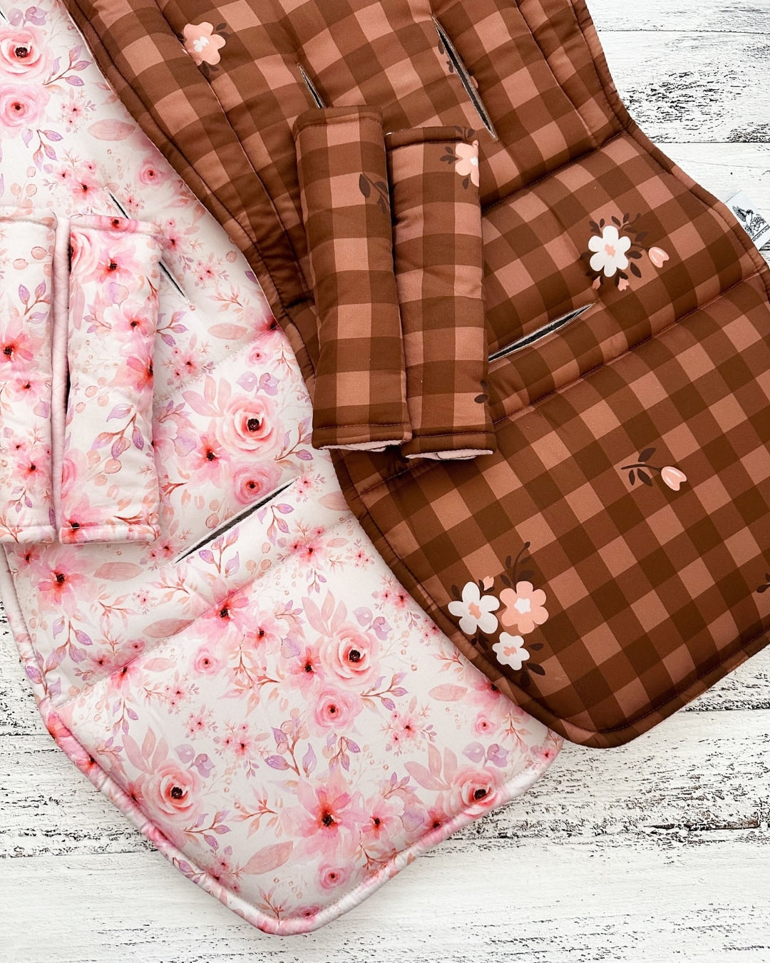 Close up reversible pram liner pink floral and brown gingham with harness pads