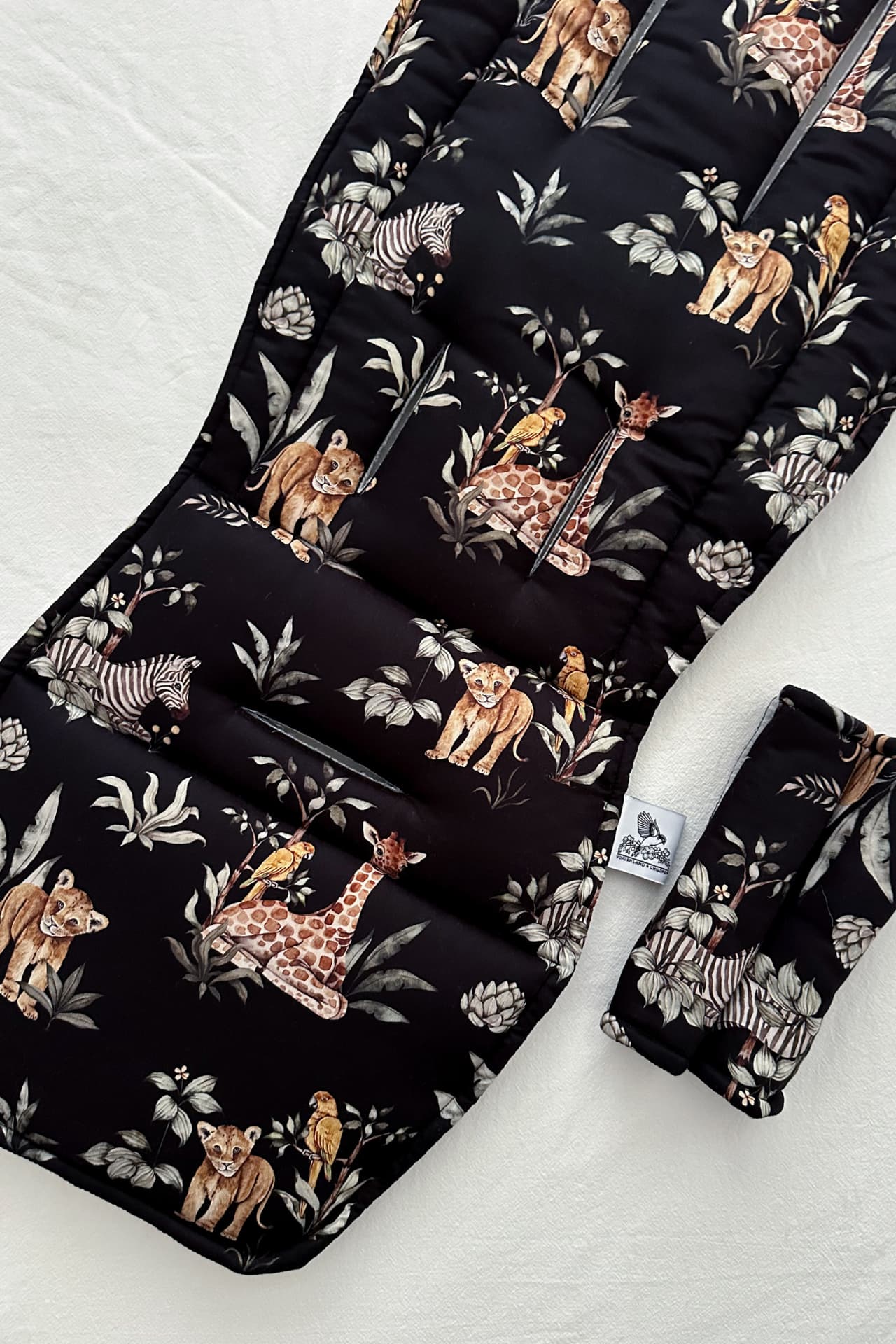 Black pram liner with animal pattern on a white surface