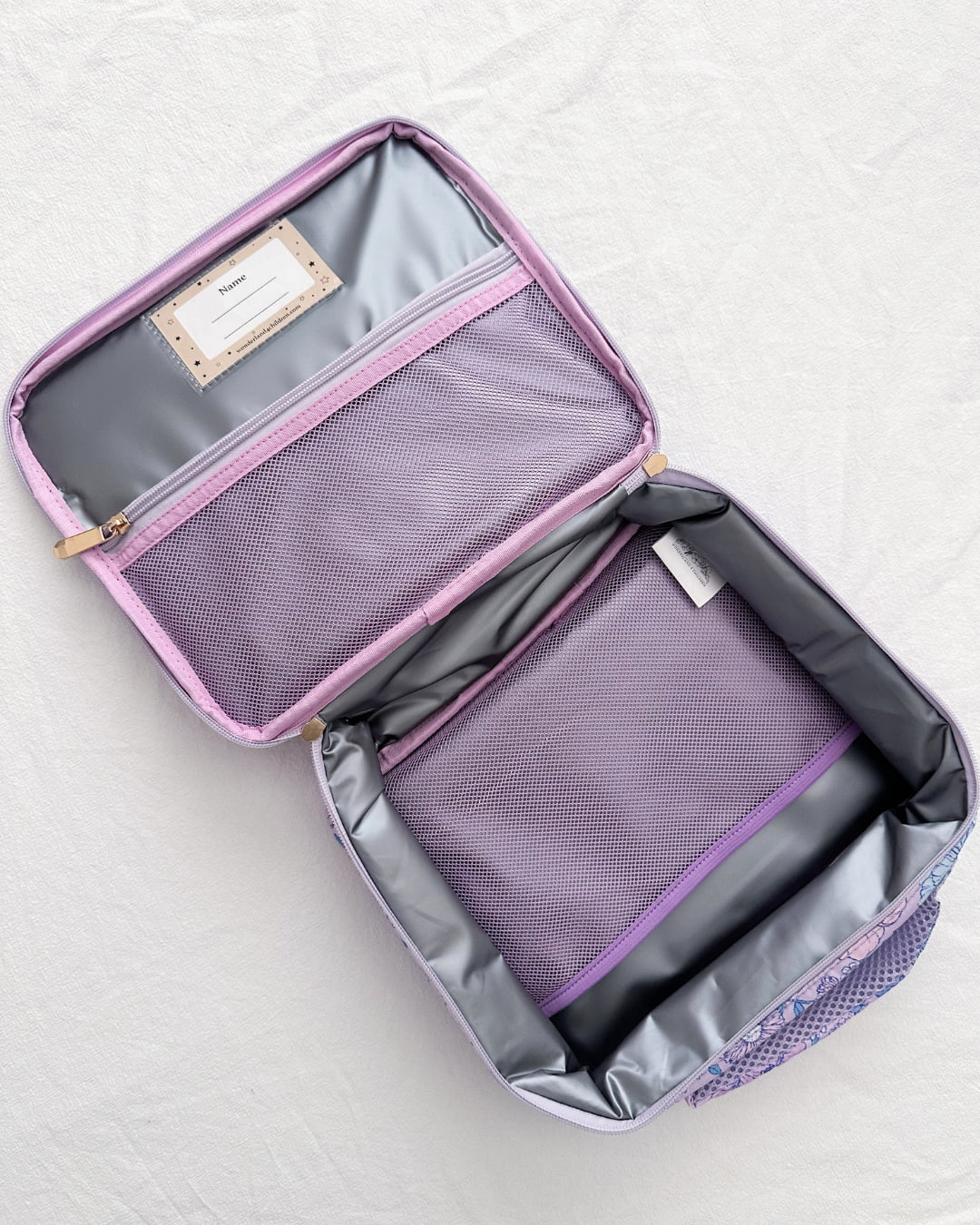 Purple travel bag with open compartment on a white background