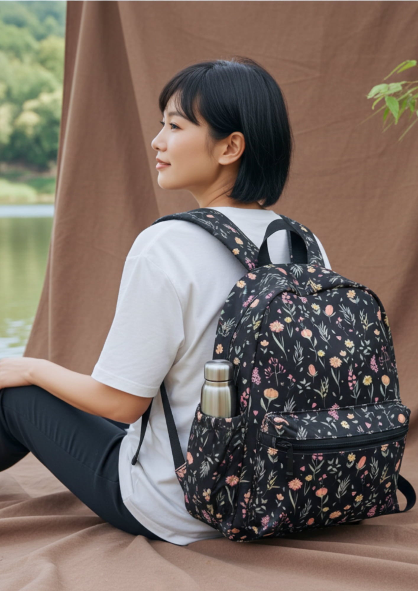 Woman sitting outdoors wearing a floral-patterned backpack